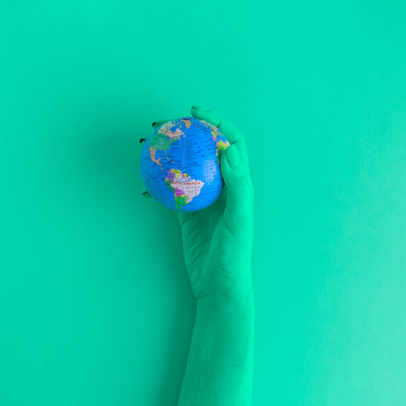 Green hand holding globe map model toy. Save the earth ecology creative minimal concept.の写真素材