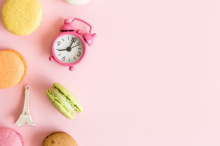 Flat lay of colorful macaroons, small alarm clock and Eiffel Tower French food and culture minimal concept. Space for copy.の写真素材