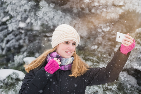 Happy woman taking selfie over winter background.の写真素材