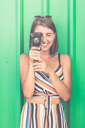Portrait of beautiful girl using vintage video camera.の写真素材