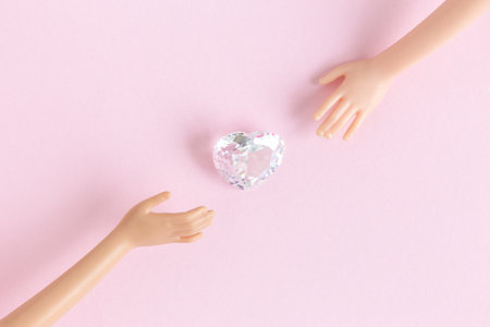 Diamond with doll hands against pastel pink background minimal creative concept.の写真素材