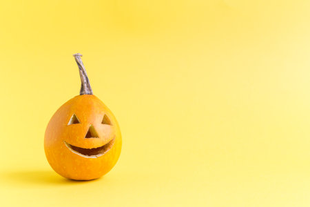 Halloween pumpkin isolated on yellow background minimal creative concept. Space for copy.の写真素材