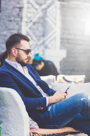 Businessman sitting in cafe and using mobile phone.の写真素材