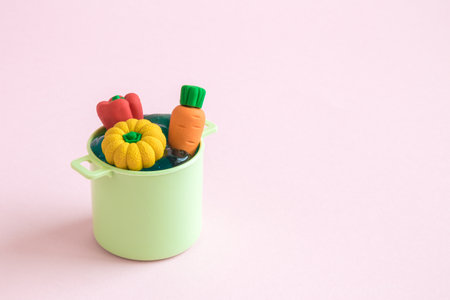 Vegetables in pot toy minimal creative cooking concept. Space for copy.
