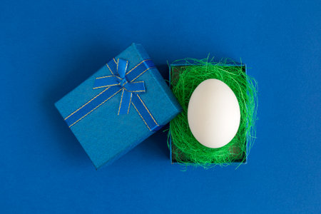 Flat lay of white egg in gift box minimal creative easter concept.