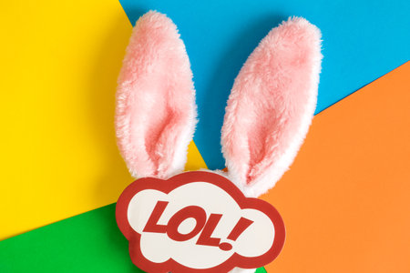 Bunny ears and lol text in speech bubble against colorful background minimal easter creative concept.の写真素材