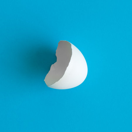 Egg shell against pastel blue background minimal creative easter concept.の写真素材