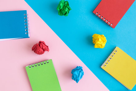 Flat lay of multicolored notepads and crushed paper abstract.の写真素材
