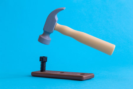 A hammer nail hit into a wooden plank minimal creative construction concept.の写真素材