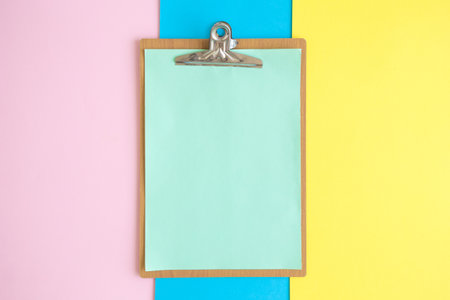 Flat lay of blank clipboard on colorful pastel background minimal creative concept.の写真素材