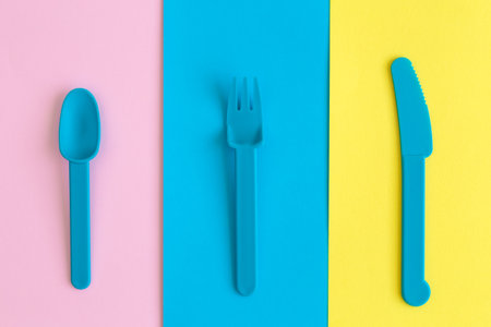 Plastic cutlery on multicolored background abstract.の写真素材