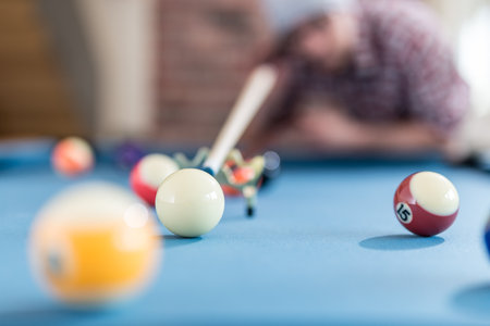 Close up shot of hipster guy aiming the billiards ball.の写真素材