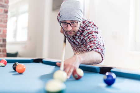 Portrait of hipster man playing billiards.の写真素材