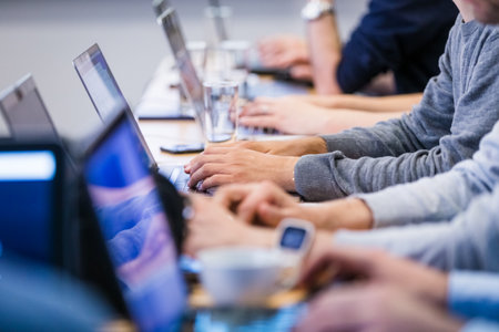 Close up of hands on laptops on a meeting or business conference.の写真素材
