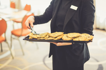 Close up of waitress holding a plate with fresh homemade cookies.の写真素材