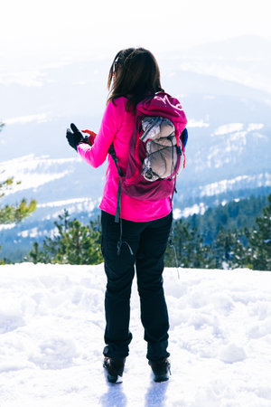 Rear view of female enjoying the view of beautiful winter mountains.の写真素材