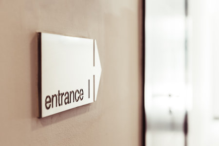 Entrance sign with direction arrow on the wall in modern building.の写真素材