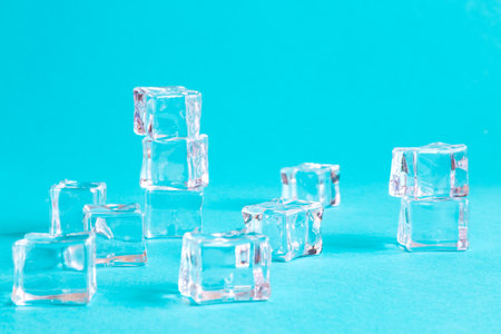 Ice cubes on bright blue background minimal summer drink creative concept.の写真素材
