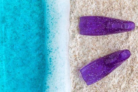Flat lay of turquoise ocean with waves and snorkel fins on sandy beach minimal summer vacation creative concept.の写真素材