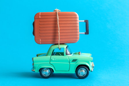 Suitcase on car roof on blue background minimal creative travel concept.の写真素材