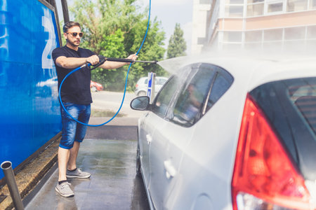 Man washing his car at car wash station.の写真素材