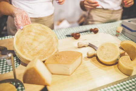 Close up of hand holding cheese at street food stand.の写真素材