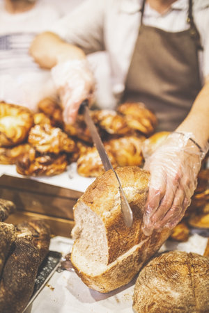 Man hands slicing home made bread.