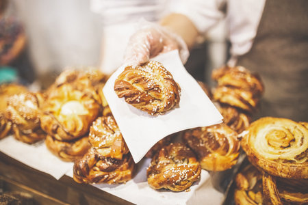 Close up of baker hand holding puff pastry stuffed with cheese.の写真素材
