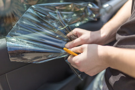 Process of removing sunlight protective car window glass foil.の写真素材