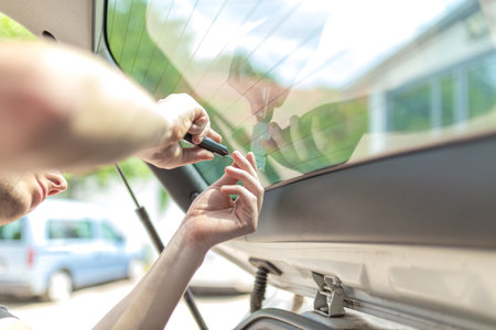 Close up shot hands of man removing old car window filmの写真素材
