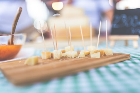 Cubes of traditional handmade cheese with toothpicks on street food market stand.の写真素材
