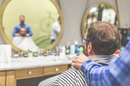 Rear view of man client in barber shop.の写真素材