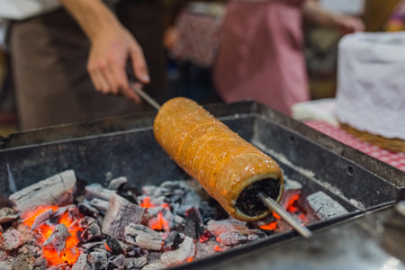 Chimney cake preparation. Chimney cake is being roasted over the fire. Street food concept.の写真素材