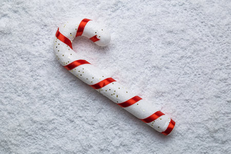 Flat lay of christmas candy on snow. Minimal sweet food holiday creative concept.