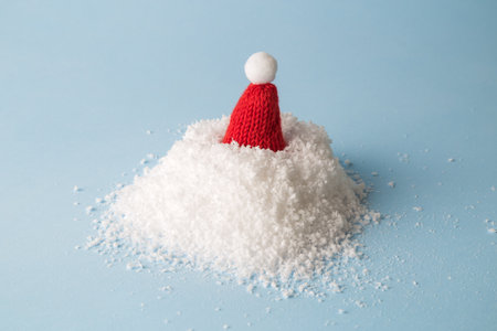 Snow heap with knitted hat abstract on pastel blueの写真素材