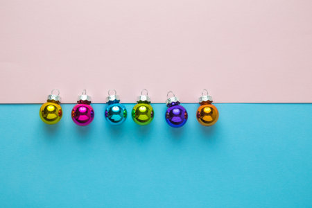 Flat lay of colorful baubles on pastel blue and pink background minimal creative christmas concept. Space for copy.の写真素材