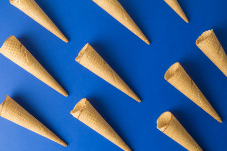 Ice cream cones pattern on classic blue background. Sweet food and summer minimal creative concept.