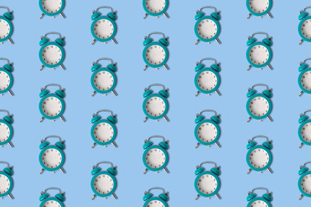 Small blue alarm clocks without hands pattern minimal creative no time concept.の写真素材