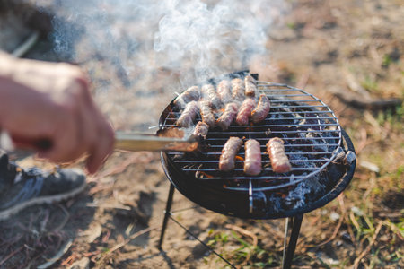 Man hand preparing kebabs on grill in nature.の写真素材