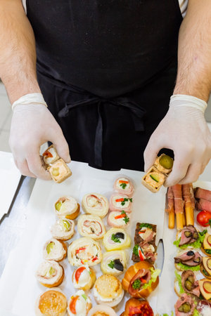 Chef preparing finger food on paper plate for delivery.の写真素材