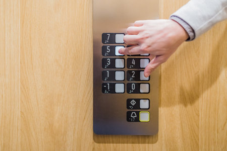 Forefinger pressing fifth floor button in the elevator. Space for copy.の写真素材