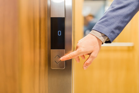 Close up of businessman hand pressing modern elevator button. Space for copy.の写真素材