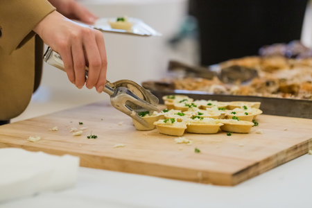 Woman choosing delicious celebration finger food at table.