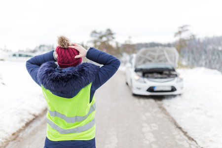 Frustrated female driver with hands on her head. Car breakdown road assistance concept. Winter...