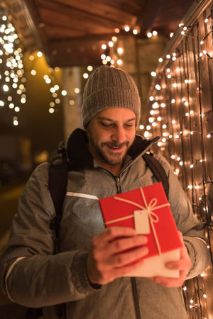 Man opening gift box outdoors. Christmas new year surprise concept.の写真素材