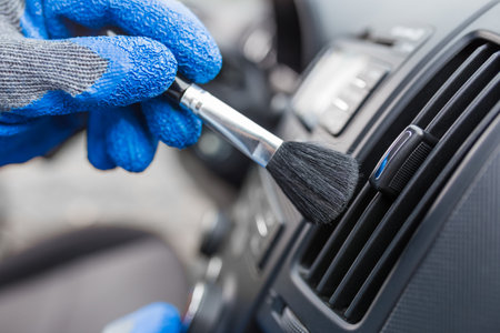 Worker cleaning automobile air conditioner vent grill with brush, closeup. Car wash serviceの写真素材
