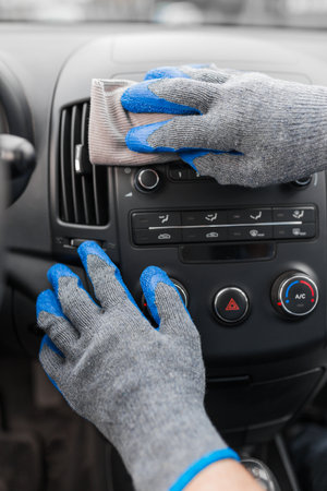 Auto service staff hand cleaning car interior with microfiber cloth. Car detailing and valeting...