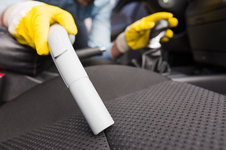 Close up of man cleaning car seat with vacuum cleaner.の写真素材