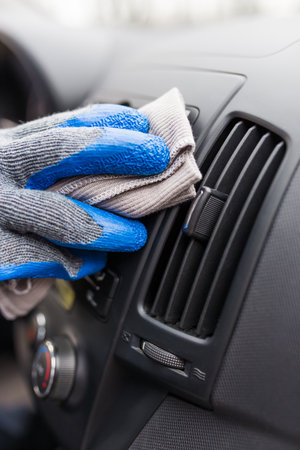 Close up of worker hand cleaning car dashboard.の写真素材