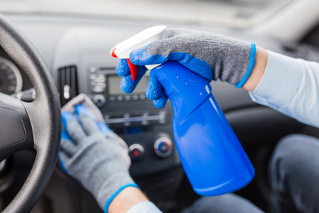 Man cleansing car dashboard and spraying with disinfection liquid.の写真素材